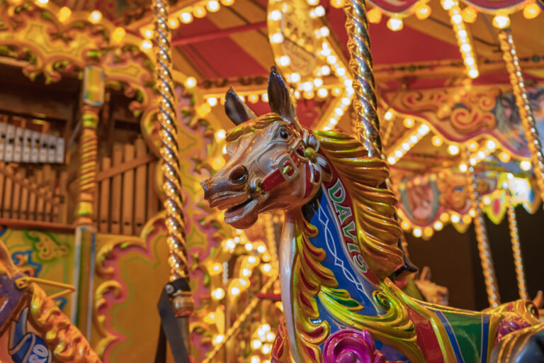 Closeup night time image of a galloping horse fairground ride