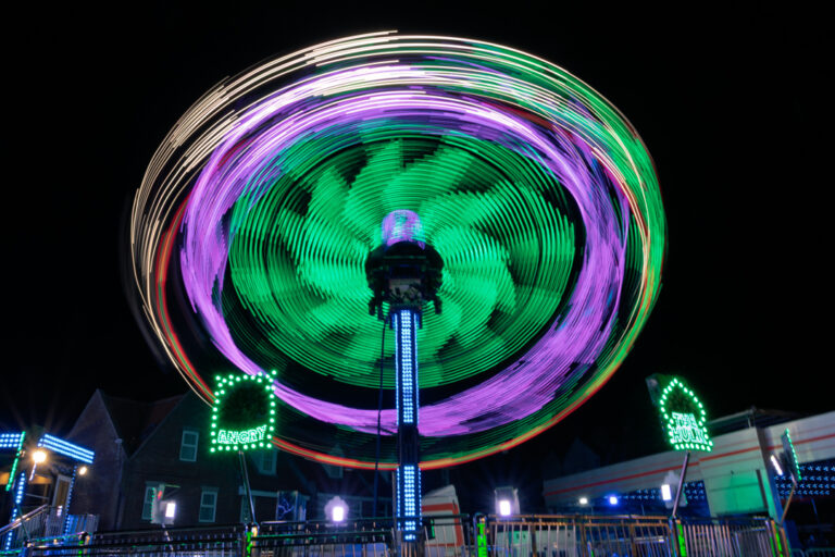 Long exposure night time shot of a fairground ride called The Hulk